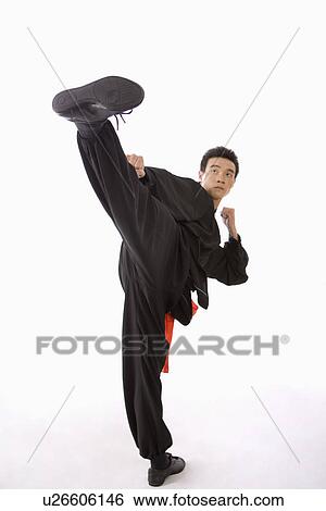 Stock Photograph - Young man performing martial arts kick studio shot. Fotosearch