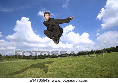 Stock Photo - Young man wearing martial arts uniform performing the Kung Fu eagle stance. Fotosearch