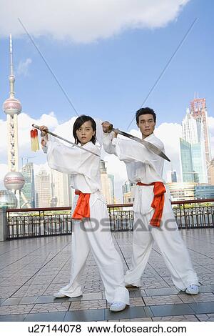 Young woman and man practicing martial arts with swords on the bund View Large Photo Image Stock Photo - Young woman and man practicing martial arts with swords on the bund. Fotosearch