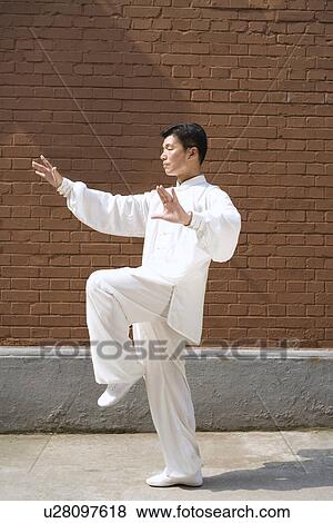 Man doing Tai Chi in front of surrounding wall View Large Photo Image Stock Photo - Man doing Tai Chi in front of surrounding wall. Fotosearch