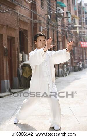 Stock Image - Man doing Tai Chi in Shiku Gate. Fotosearch
