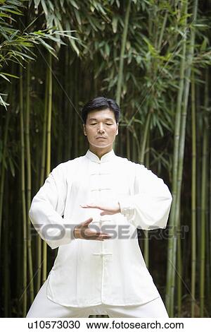 Stock Image - Man doing Tai Chi outdoors. Fotosearch