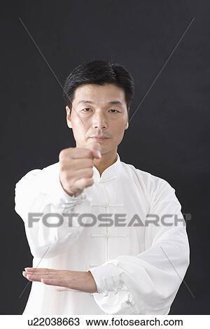 Man practicing Tai Chi against black background View Large Photo Image Stock Image - Man practicing Tai Chi against black background. Fotosearch