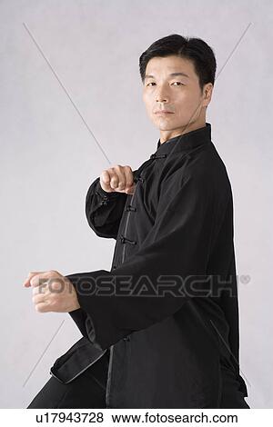 Stock Photo - Man practicing Tai Chi in studio shot. Fotosearch