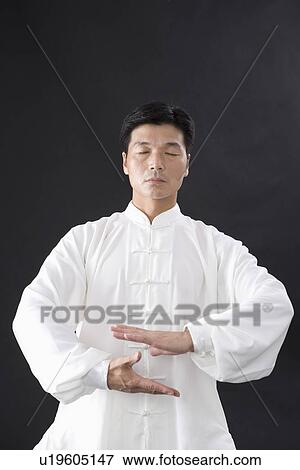 Stock Photo - Man practicing Tai Chi with eyes closed. Fotosearch