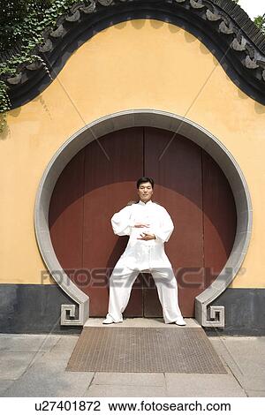 Stock Image - Mature man practicing Tai Chi in LongHua temple. Fotosearch