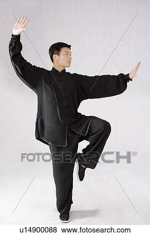 Portrait of man posing in Tai Chi position in studio shot View Large Photo Image Stock Photo - Portrait of man posing in Tai Chi position in studio shot. Fotosearch