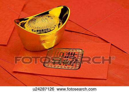 Stock Photograph - A bowl full of gold coins on red envelope. Fotosearch