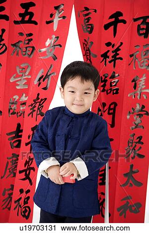 Boy in Chinese traditional clothes with red envelopes standing, Calligraphy in the background View Large Photo Image Stock Image - Boy in Chinese traditional clothes with red envelopes standing, Calligraphy in the background. Fotosearch