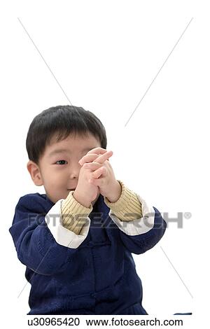 Stock Image - Boy in Chinese traditional clothes with hands clasped. Fotosearch