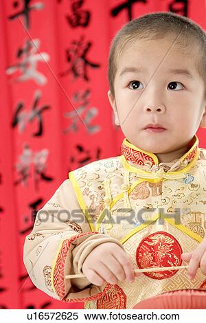 Boy in Chinese traditional clothes with lantern standing, looking away, Calligraphy in the background View Large Photo Image Stock Photography - Boy in Chinese traditional clothes with lantern standing, looking away, Calligraphy in the background. Fotosearch
