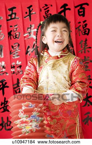 Picture - Girl in Chinese traditional clothes with lantern standing and laughing. Fotosearch