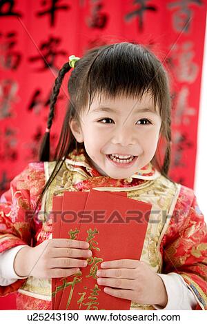 Girl in Chinese traditional clothes holding red envelopes standing and laughing View Large Photo Image Stock Image - Girl in Chinese traditional clothes holding red envelopes standing and laughing. Fotosearch