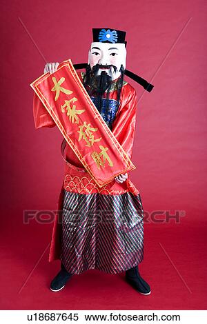 Stock Photography - Young man in costume presenting Chinese luck poem. Fotosearch