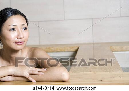Picture - Young woman bathing in tub. Fotosearch
