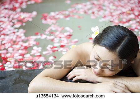 Young woman in pool with rose petals, resting View Large Photo Image Picture - Young woman in pool with rose petals, resting. Fotosearch
