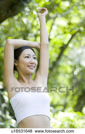 Young woman standing in woods, posing View Large Photo Image Stock Photo - Young woman standing in woods, posing. Fotosearch