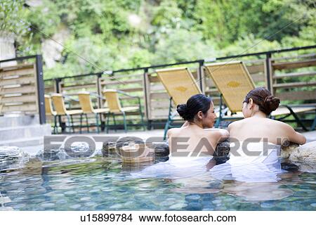 Young women with towel bathing in hot spring, rear view View Large Photo Image Picture - Young women with towel bathing in hot spring, rear view. Fotosearch