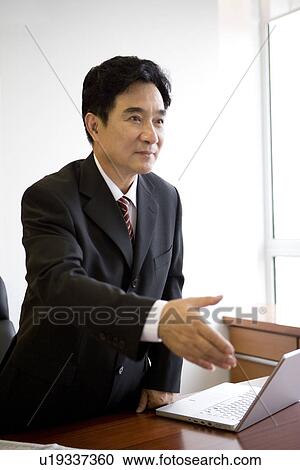 Stock Image - Businessman extending hand to shake. Fotosearch