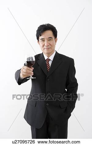 Businessman holding a glass of wine in studio shot View Large Photo Image Stock Photograph - Businessman holding a glass of wine in studio shot. Fotosearch