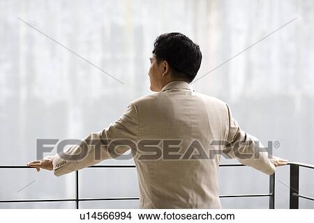 Picture - Businessman leaning on railing. Fotosearch