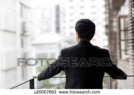 Businessman leaning on railing, rear view View Large Photo Image Stock Image - Businessman leaning on railing, rear view. Fotosearch