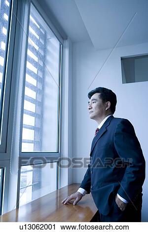 Businessman looking through window View Large Photo Image Stock Image - Businessman looking through window. Fotosearch