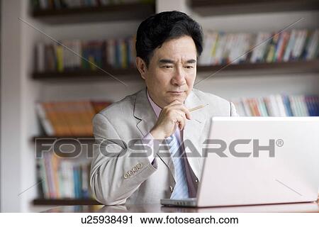 Stock Image - Businessman on the phone pulling suitcase for business travel outdoors. Fotosearch