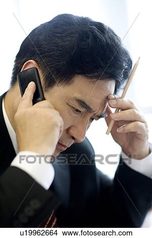 Picture - Businessman on the phone with pencil. Fotosearch