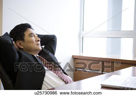 Businessman reclining on office chair View Large Photo Image Stock Photograph - Businessman reclining on office chair. Fotosearch