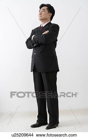 Picture - Businessman with arms crossed in studio shot. Fotosearch