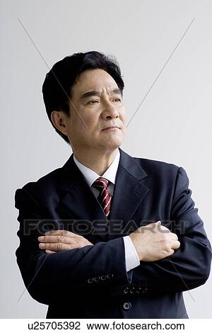 Businessman with arms crossed in studio shot View Large Photo Image Stock Image - Businessman with arms crossed in studio shot. Fotosearch