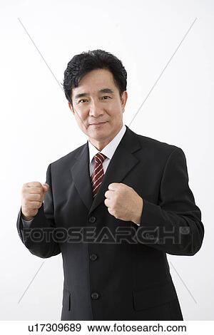 Stock Photo - Businessman with fists looking at camera. Fotosearch