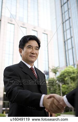 Businesspeople shaking hands outdoors View Large Photo Image Stock Photo - Businesspeople shaking hands outdoors. Fotosearch