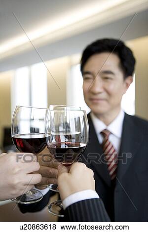 Businesspeople toasting glasses in office View Large Photo Image Stock Photo - Businesspeople toasting glasses in office. Fotosearch