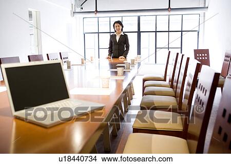 Businesswoman at head of table in boardroom View Large Photo Image Picture - Businesswoman at head of table in boardroom. Fotosearch