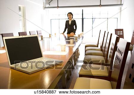 Stock Photo - Businesswoman at head of table in boardroom. Fotosearch