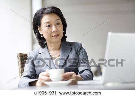 Stock Image - Businesswoman in coffee shop. Fotosearch