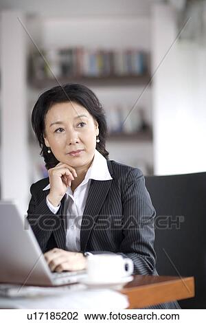 Stock Image - Businesswoman in office. Fotosearch