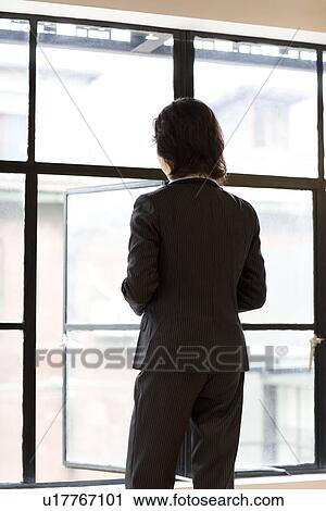 Businesswoman looking through window View Large Photo Image Stock Image - Businesswoman looking through window. Fotosearch