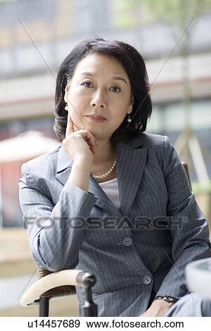 Stock Photo - Businesswoman sitting outdoors. Fotosearch