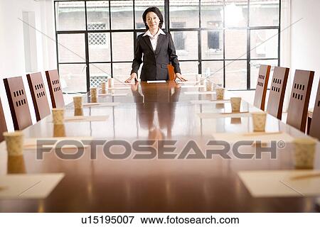 Businesswoman standing at conference table View Large Photo Image Stock Photo - Businesswoman standing at conference table. Fotosearch
