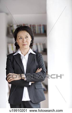 Stock Image - Businesswoman standing in office. Fotosearch