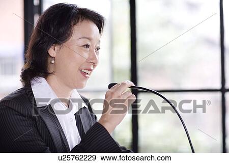 Stock Photo - Businesswoman talking on microphone. Fotosearch