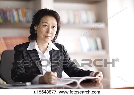 Stock Photo - Businesswoman working in office. Fotosearch