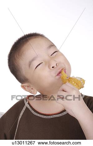 Boy eating fried chicken leg, smiling, portrait View Large Photo Image Stock Photo - Boy eating fried chicken leg, smiling, portrait. Fotosearch