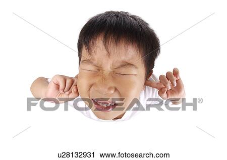 Stock Image - Boy holding fingers in ears. Fotosearch