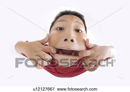 Boy pulling his mouth with fingers, high angle view View Large Photo Image Stock Photo - Boy pulling his mouth with fingers, high angle view. Fotosearch