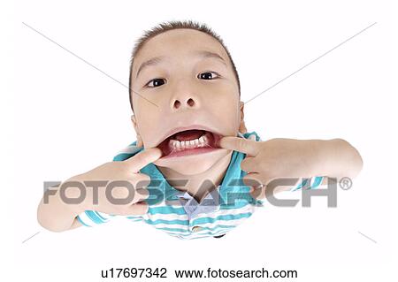 Stock Image - Boy pulling mouth, portrait. Fotosearch