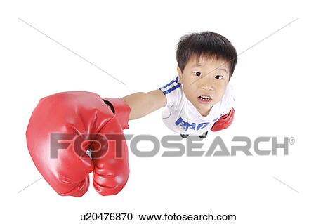 Stock Image - Boy wearing boxing gloves, portrait, close up. Fotosearch